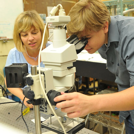 NUM faculty member helps a high school student with a STEM workshop project